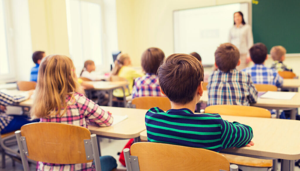 group of school kids and teacher in classroom